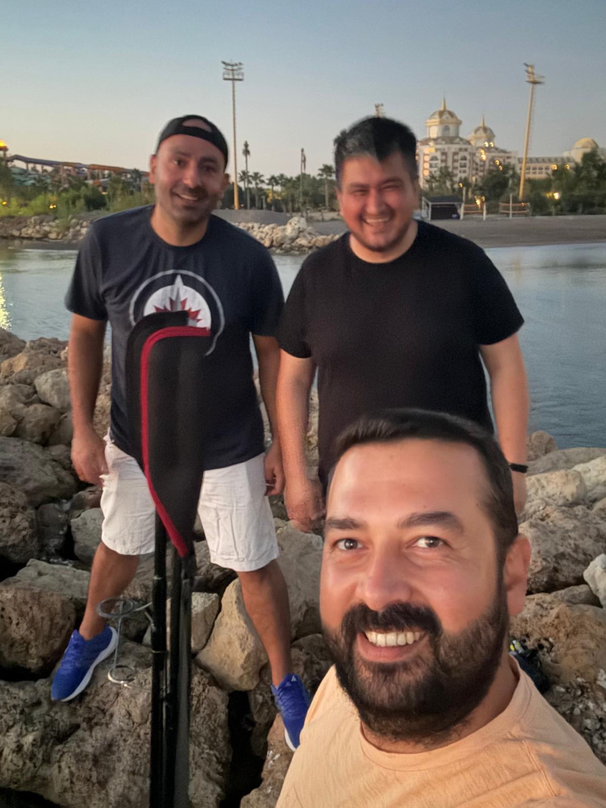 Deniz kenarında balık avı ekipmanıyla bir araya gelen üç arkadaş